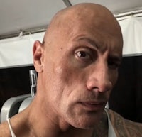 a bald man with tattoos is taking a selfie