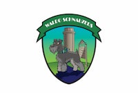 a schnauzer logo with a dog standing in front of a tower